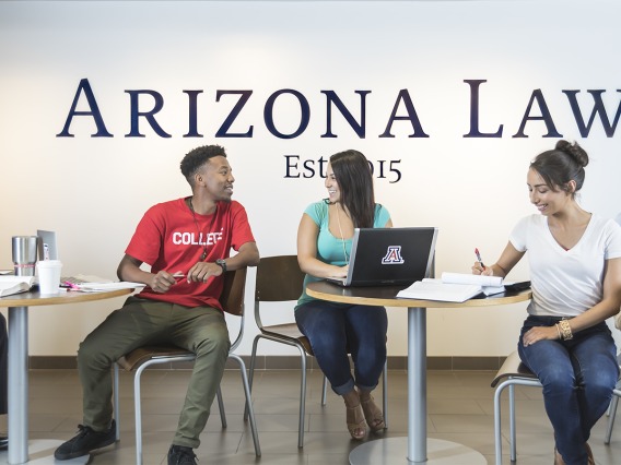 Five students studying at tables in front of a wall that says Arizona Law.