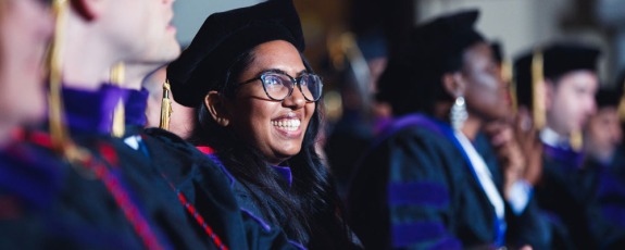 Woman in law school graduation regalia smiling