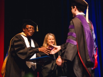 University of Arizona Law Assistant Dean of Student Affairs Willie Jordan-Curtis congratulates a student at graduation